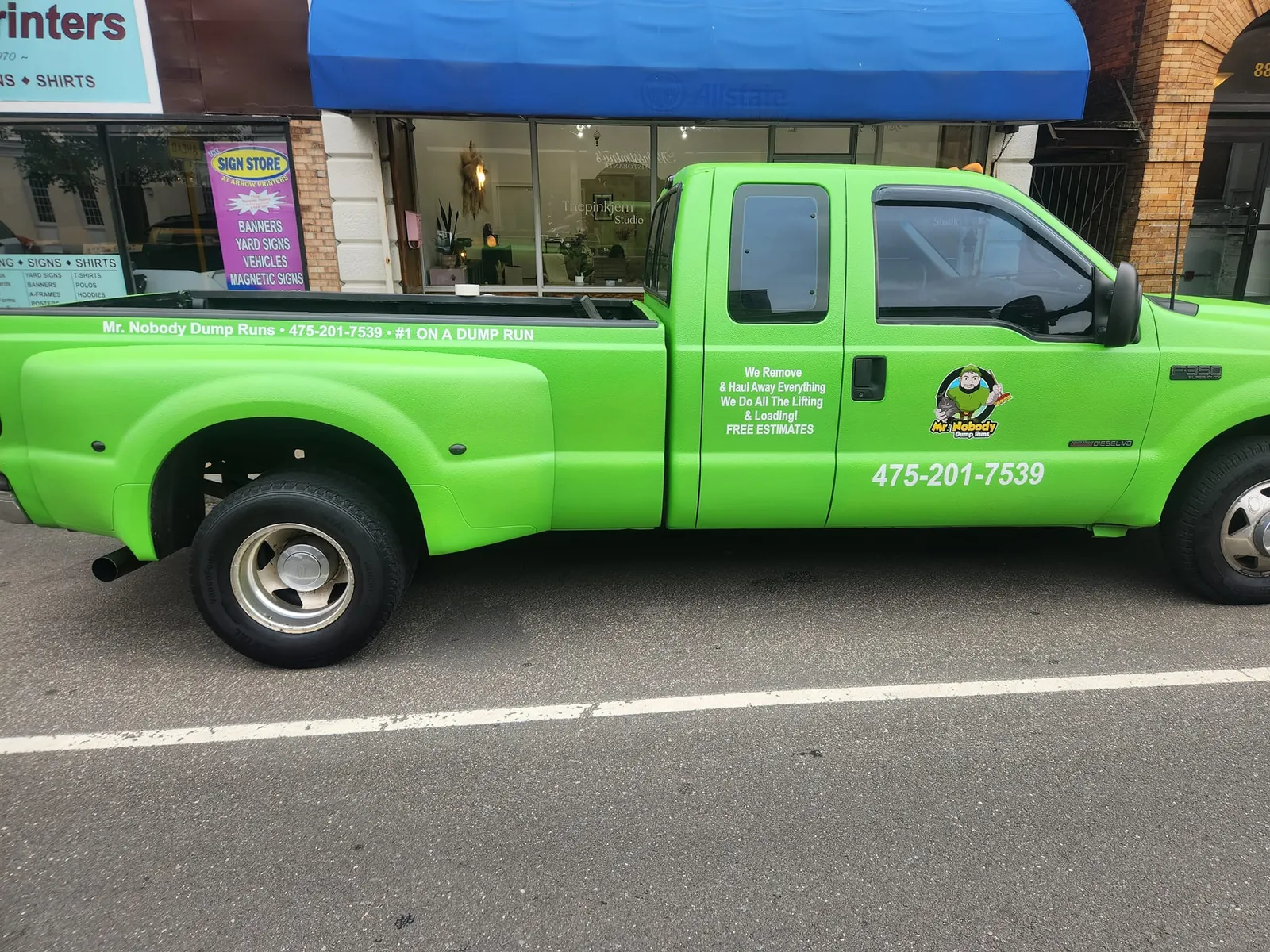 Bright green Mr. Nobody Dump Runs pickup truck parked on a street in Connecticut